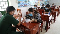 Lấy lời khai, lý lịch các công dân được trao trả từ Campuchia về Việt Nam. Ảnh: TTXVN.