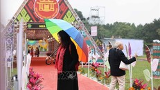 Thời tiết mưa lạnh, song những người yêu thơ vẫn tới Hoàng thành Thăng Long, trên con đường thơ đọc và chiêm nghiệm những vần thơ hay. Ảnh: Thanh Tùng/TTXVN