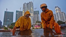 Cơn mưa bắt đầu lúc 16h30 và kết thúc sau đó khoảng 1 giờ nhưng nước đã ngập sâu ở đường Nguyễn Hữu Cảnh. Công nhân cấp thoát nước đô thị phải tích cực dọn cống để chống ngập.