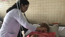 Bác sĩ đang thăm khám cho cụ ông và dị vật được gắp ra.