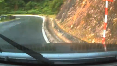 Bị mất lái khi vào cua trên đường đèo ướt, ôtô suýt đâm vào vách đá