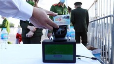 Người dân trước khi vào sân sẽ phải dùng thẻ căn cước công dân gắn chip để thực hiện quét mã, chỉ những người hiện kết quả màu xanh (đã tiêm đủ 2 mũi) mới đủ điều kiện vào sân. (Ảnh: Phạm Kiên/TTXVN)