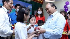 Chủ tịch nước Nguyễn Xuân Phúc tặng quà cho trẻ khuyết tật. (Ảnh An Đăng/TTXVN)