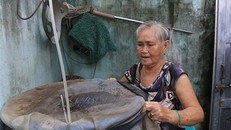 Người dân che đậy dụng cụ chứa nước, không để muỗi có chỗ sinh sản. (Ảnh: Nhựt An/TTXVN)