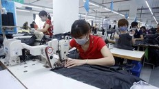 Công nhân sản xuất sản phẩm may mặc. (Ảnh: Phạm Kiên/TTXVN)