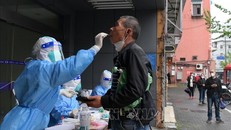 Nhân viên y tế lấy mẫu xét nghiệm COVID-19 cho người dân tại Thượng Hải, Trung Quốc ngày 26/4/2022. Ảnh: THX/TTXVN