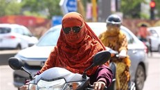 Người dân mặc áo chống nắng bảo vệ dưới thời tiết nắng nóng gay gắt tại Bhopal, bang Madhya Pradesh, Ấn Độ, ngày 6/7/2023. (Ảnh: THX/TTXVN)