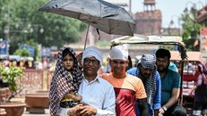 Người dân che ô tránh nắng nóng tại New Delhi, Ấn Độ, ngày 21/5/2024. Ảnh: AFP/TTXVN