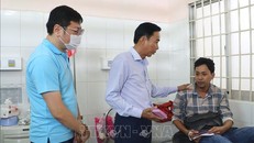 Lãnh đạo Liên đoàn Lao động tỉnh Vĩnh Long và Công ty TNHH Bo Hsing thăm và động viên công nhân đang nằm viện điều trị. Ảnh: Lê Thúy Hằng/TTXVN