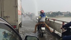 Mặc áo mưa giữa trời nắng để qua cầu Chương Dương