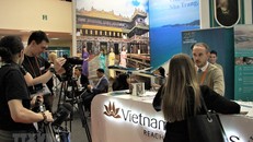 Phóng viên quốc tế tác nghiệp tại gian hàng Việt Nam tại hội chợ MITT. (Ảnh: Hồng Quân/TTXVN)