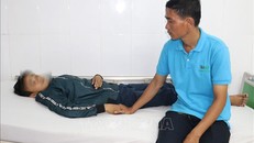 Anh Nguyễn Hữu Tri chăm sóc em Thọ tại Phòng cấp cứu Bệnh viện Sản nhi An Giang sau khi bị nhóm bạn học cùng trường đánh hội đồng.