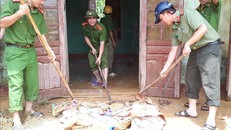 Các chiến sỹ công an huyện Hương Khê chung tay vệ sinh môi trương sau lũ tại xã Hương Đô. Ảnh: Phan Quân/TTXVN