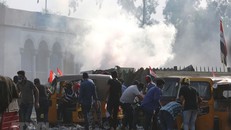 Người biểu tình chạy trốn đạn hơi cay của lực lượng an ninh khi tiếp cận vùng Xanh tại thủ đô Baghdad, Iraq ngày 27/10/2019. (Ảnh: THX/TTXVN)