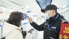 Nhân viên kiểm tra thân nhiệt của hành khách tại một nhà ga ở Vũ Hán, tỉnh Hồ Bắc, Trung Quốc. (Ảnh: THX/TTXVN)