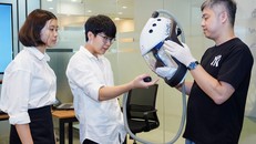 Hai bạn Đức, An (bên trái) và thầy Trịnh Minh Giang, Chủ tịch YDLI - vườn ươm tài năng trẻ, trao đổi về sản phẩm. Ảnh: P. Nam.