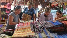 Du khách người nước ngoài tìm hiểu về sản phẩm thổ cẩm được trưng bày tại quán Mê Linh Garden, Đà Lạt. Ảnh: Nguyễn Dũng/TTXVN