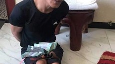 Thiện khi bị cảnh sát bắt giữ tại khách sạn cùng số tiền 400 triệu đồng. Ảnh: Anh Minh.