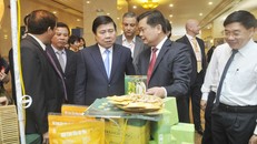 Chủ tịch UBND tỉnh Nghệ An Thái Thanh Quý giới thiệu với Chủ tịch UBND TP. Hồ Chí Mnh Nguyễn Thành Phong sản phẩm của doanh nghiệp Nghệ An. (Ảnh: Cao Thắng)