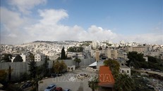 Bức tường ngăn cách khu vực Đông Jerusalem (trái) và ngôi làng Abu Dis của người Palestine. Ảnh: AFP/TTXVN