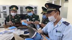 Lực lượng chức năng kiểm đếm số khẩu trang bị thu giữ. (Ảnh: Công Mạo/TTXVN)