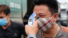 Kiểm tra thân nhiệt người đi đường tại các trạm kiểm soát dịch COVID-19. 