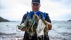 Chuyên gia tổ chức bảo vệ môi trường OceansAsia thu nhặt khẩu trang dùng một lần trên bãi biển vùng đảo Lantau, Hong Kong, Trung Quốc. Ảnh: AFP/TTXVN