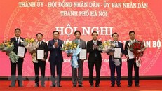 Bí thư Thành ủy Vương Đình Huệ và Chủ tịch UBND thành phố Chu Ngọc Anh trao quyết định và tặng hoa chúc mừng năm tân Phó Chủ tịch UBND thành phố Hà Nội. (Ảnh: Văn Điệp/TTXVN)