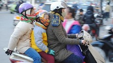 Phụ huynh chở con đi học giữa trời rét