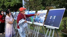 Khách du lịch quốc tế tham quanTriển lãm ảnh "Chuyện làng biển" tại ngày hội. 