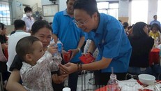 Đồng chí Nguyễn Thành Đô, Trưởng Ban Chính sách pháp luật Liên đoàn Lao động Thành phố lì xì cho con các gia đình công nhân lao động tham dự Chương trình “Tết sum vầy” năm 2021. (Ảnh: Đảng bộ TP HCM) 