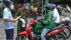 Một shipper bị chặn tại chốt kiểm soát lưu thông tại huyện Nhà Bè (TP HCM) vào ngày 26/7. Ảnh: VnExpress.