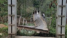 Cầu treo Nam Quang bị đứt gãy khiến xe tải chở hàng rơi xuống sông. Ảnh: TTXVN phát