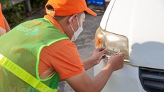 Nhân viên của Công ty cổ phần Giao thông số Việt Nam (VDTC) dán thẻ thu phí không dừng cho phương tiện. (Ảnh: Minh Sơn/Vietnam+) 