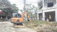 Huyện Ba Vì (Hà Nội) huy động phương tiện cơ giới thực hiện cưỡng chế tháo dỡ, cây, tường rào...trong phạm vi giải phóng mặt bằng. (Ảnh Mạnh Khánh/TTXVN)