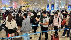 Hành khách xếp hàng dài chờ vào khu vực kiểm tra giấy tờ tùy thân và soi chiếu an ninh tại sân bay Nội Bài. (Ảnh: CTV/Vietnam+)