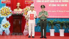 Thứ trưởng Bộ Công an Lương Tam Quang (phải) trao Quyết định và tặng hoa Đại tá Hồ Việt Triều, Giám đốc Công an tỉnh Bạc Liêu. (Ảnh: TTXVN phát)
