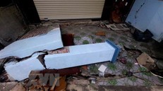 Cổng, tường nhà của nhiều hộ dân tổ 6, khu 3B, phường Giếng Đáy bị sập, hư hỏng. (Ảnh: Thanh Vân/TTXVN)