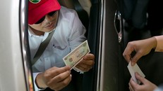 Một tài xế đưa tiền lẻ và được thối 100 đồng. Ảnh: Nguyễn Thành.