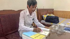 Thạc sĩ Lê Từ Hiển ký sách. Ảnh: Tiến Dũng