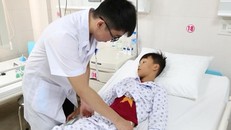 Bệnh nhi Đ.Q.K. được bác sĩ thăm khám sau phẫu thuật (Ảnh: Bệnh viện cung cấp)