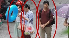 Bức ảnh trích xuất từ camera an ninh cho thấy cô bé Zhang Zixin bị 2 người lớn dẫn đi. (Ảnh: Getty).