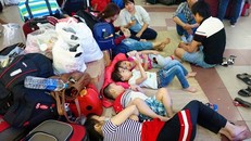 Các em nhỏ đi theo người lớn cũng mệt mỏi và phải nằm bệt dưới sảnh nhà ga