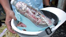 Nhân viên trạm thu phí nhận tiền trong chai nhựa của tài xế rồi đưa đến nơi khác đếm để tránh kẹt xe. Ảnh: Hoàng Nam.