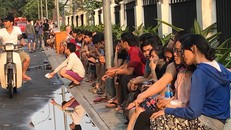 Cư dân hoảng hốt ngồi nhìn hiện trường vụ cháy. (Ảnh NLĐ)