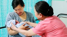 Hai mẹ con sản phụ Trương Thị Thu đang được nữ hộ sinh Văn Thị Ái Lân chăm sóc tại Bệnh viện đa khoa Gia Đình - Đà Nẵng 