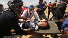 Chuyển người biểu tình Palestine bị thương sau các cuộc đụng độ với binh sỹ Israel tại khu vực biên giới Dải Gaza với Israel ngày 14/5. (Nguồn: AFP/TTXVN)