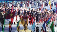 Tình nguyện viên nước chủ nhà rước quốc kỳ Việt Nam tiến vào sân VĐV Bung Karno trong lễ bế mạc Asiad 2018