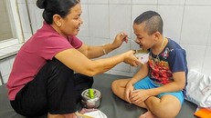 Cậu bé luôn ngoan ngoãn, ngồi ăn cơm bà nội đút. Ảnh: Thúy Quỳnh