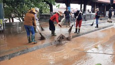 Người dân vệ sinh môi trường sau lũ lụt, phòng dịch bệnh. Ảnh: TTXVN